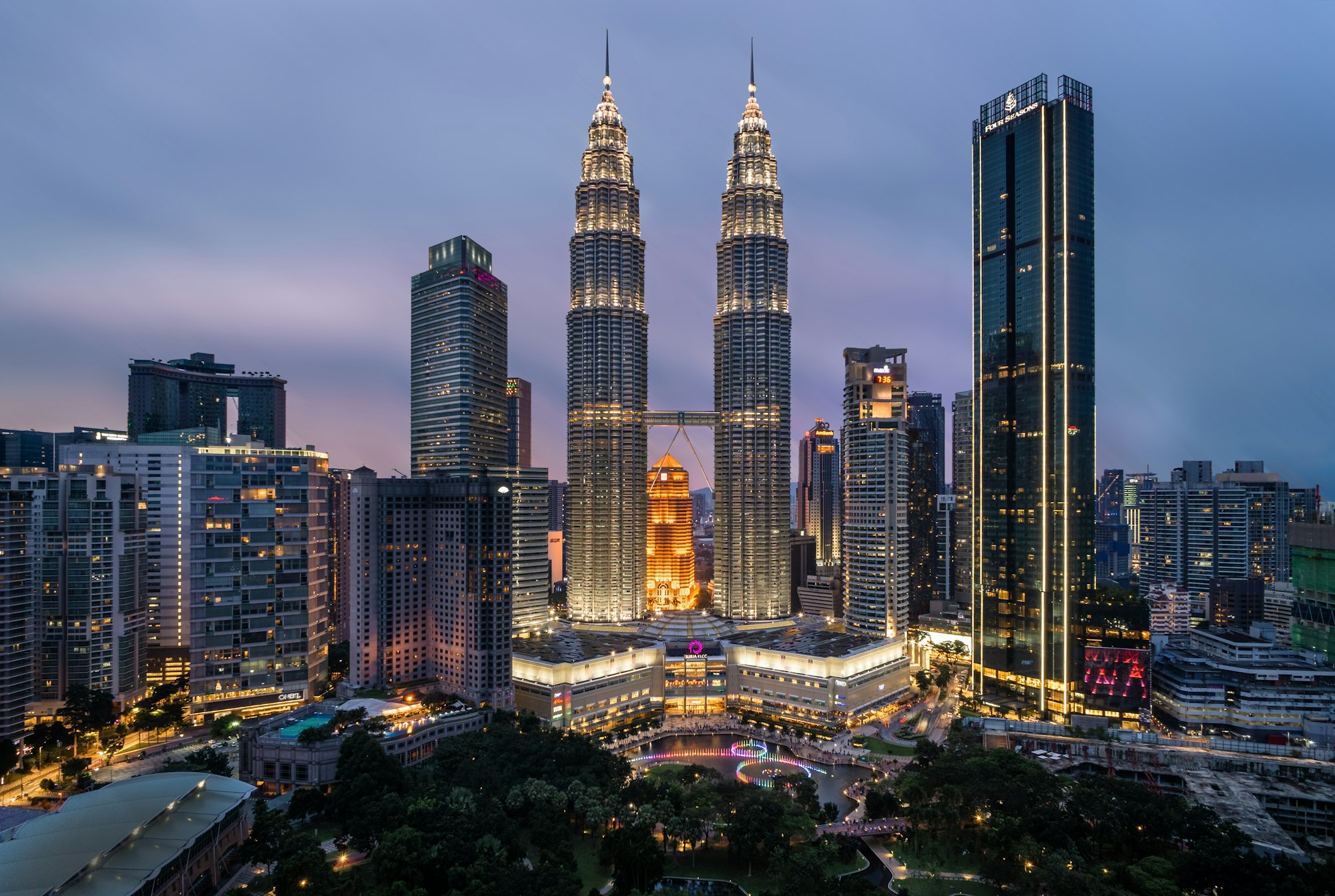 Petronas Twin Towers illuminated against dusk sky in Kuala Lumpur, Malaysia